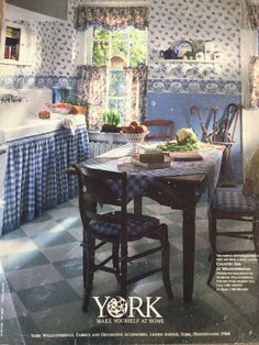 an old fashioned kitchen with blue and white wallpaper, checkered table cloths and chairs