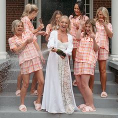 a group of women dressed in pink and white posing on the steps with each other