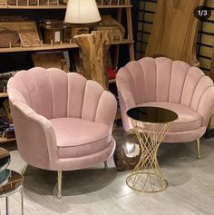 two pink chairs sitting next to each other on top of a floor in a room