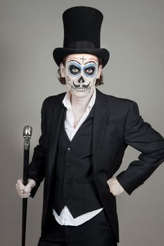 a man in a top hat and skeleton makeup holding a cane