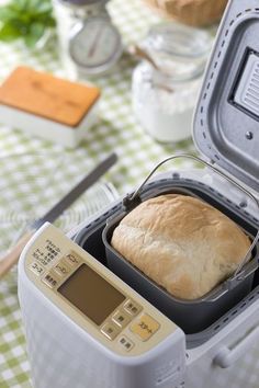 a loaf of bread sitting in an open container on top of a checkered table cloth