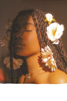 a woman with dreadlocks and flowers in her hair is looking at the camera