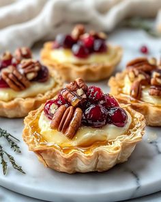 small tarts with cranberry sauce and pecans on a marble platter