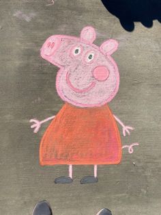 a drawing of a peppo pig on the ground next to someone's feet