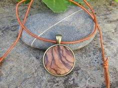 "Lovely bronze pendant medallion with a handmade cabochon Ø 25 mm - 0.98 inches in fine olive wood with a 75 cm - 29.5 inches long bronze plated chain or an adjustable leather cord 1 meter ( 39.37 \" ) naturally the grain of the olive wood can vary from item to item , but in any case you will get a pendant with an olive wood cabochon with beautiful grain handcrafted by us in Portugal the olive wood is finely sanded and oiled with olive oil" Round Necklace In Natural Color For Gift, Round Natural Color Necklace As Gift, Nickel-free Brown Necklace For Gift, Natural Round Necklace For Gift, Natural Color Necklace For Gift, Artisan Necklaces In Natural Wood As Gift, Artisan Necklace In Natural Wood As A Gift, Artisan Natural Wood Necklace As A Gift, Artisan Natural Wood Necklaces For Gift