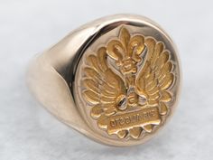 "The engraving on this signet ring is backwards, as it was likely used for wax seals! The words \"SUB ALIS STO\" are engraved, meaning \"We Stand Under Our Wings\".  Please note that this signet ring has its original monogram, unfortunately, this piece cannot be altered without affecting the quality of the piece, please feel free to contact us to help you find your perfect signet ring in your style and budget!  Metal: 14K Yellow Gold Top Measurements: 11 x 14 mm, Oval Ring Size: 3 Marks: \"BBB 14K\" Stamped on the inside band To view a video of this piece check out the link below: https://vimeo.com/832402566 SKU #: A24653 Each piece has been identified and graded by a Graduate Gemologist who has been certified by the Gemological Institute of America (GIA). We have six brick-and-mortar stor Signet Ring Gold, Vintage Family, Gold Statement Ring, Top Measurements, Gold Signet Ring, Gold Engraving, Oval Ring, Oval Rings, Gold Top