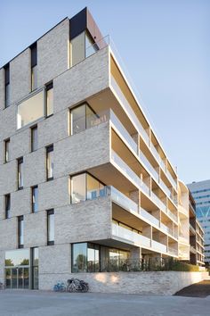 an apartment building with balconies on the side and bicycles parked in front of it