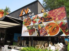 an outdoor restaurant with large menus on the front and side of it's building