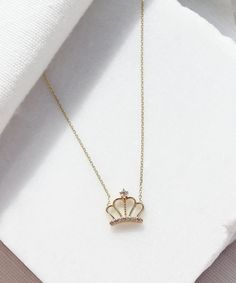 A small dainty crown hanging on a simple solid gold chain. This is a unique piece for celebrating yourself or your loved ones. It is perfect for everyday wear as it made of solid gold and won't tarnish. We promise that this necklace will be a piece you cherish forever. #aesthetic #crown #14K #gold # necklace #queen #princess #8K #bridal #cute #gift #anniversary #royalty #royal #jewellery #jewelry #jewel #minimalist Elegant Crown Design Necklace For Wedding, Gold Cubic Zirconia Teardrop Crown Jewelry, Wedding Jewelry With Crown Design, Elegant Crown Shaped Wedding Necklaces, Elegant Crown-shaped Wedding Necklaces, Teardrop Crown Jewelry With Diamond Accents For Gift, Gift Jewelry With Diamond Accents In Teardrop Shape, Crown Shaped Jewelry For Anniversary, Gold Crown Jewelry With Diamond Accents