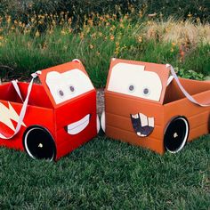 two cardboard cars are sitting in the grass