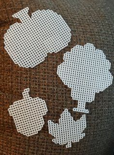 three pieces of fabric with white dots on them are sitting next to each other in the shape of an apple