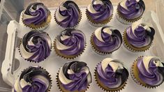 cupcakes with purple and white frosting in a box