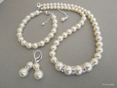 "This vintage inspired set comes with necklace, bracelet and earrings.  Swarovski pearls in your color of preference.  Makes a perfect gift for bridesmaids, maid of honor, mother of the bride or just for someone special! If you need a different color pearl contact me to check availability.  Perfect for any classy bride! Necklace, This classic and elegant necklace has graduated Swarovski pearls in ivory. Pearls in the front of the necklace measure 10 mm and are separated with rhinestone roundelles, the rest of the pearls size ranges from 8 to 6 mm. Necklace measures approximately 17\" long and is finished off with a lobster claw clasp closure and 2\" extender chain for additional length. Bracelet, Pearls measure 8 mm, length is approximately 7.5\" inches long with a 1.25\" extender chain fo Wedding Pearl Jewelry Sets With Pearl Chain, Pearl Jewelry Sets For Wedding, Pearl Jewelry Set With Pearl Charm For Wedding, Wedding Pearl Necklace With Matching Earrings, Elegant Pearl Jewelry Sets With Round Beads, Pearl Jewelry Sets With Round Beads For Wedding, Pearl White Jewelry Sets With Round Beads For Wedding, Pearl White Round Beads Jewelry Sets For Wedding, Elegant White Jewelry Sets For Bridesmaids