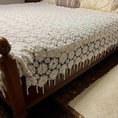 the bed is made with white crocheted bedspread