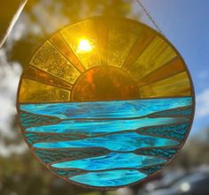 a stained glass sun catcher hanging from a chain