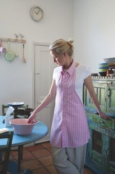 a woman standing in front of a table with a bowl on it