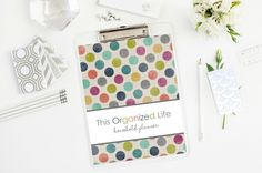 a clipboard with an organized life on it next to flowers and other office supplies