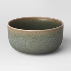 a green bowl sitting on top of a white table