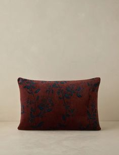 a red pillow with blue flowers on it