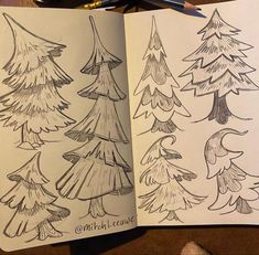 an open notebook with drawings of pine trees on the pages and pencils next to it