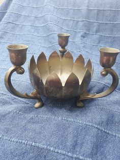 an antique silver candle holder with three candles on it's sides and two smaller ones in the middle