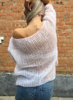 a woman standing in front of a brick wall with her back turned to the camera