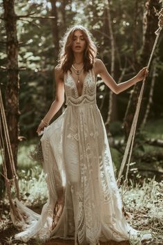 a woman in a white dress standing on a swing