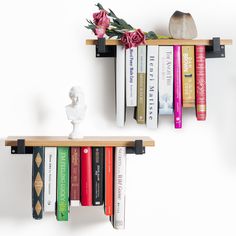 two bookshelves with flowers and vases on them