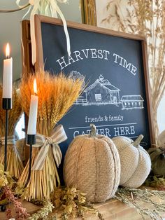 a chalkboard sign sitting on top of a table next to pumpkins and hay