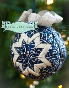 a blue and white ornament hanging from a christmas tree