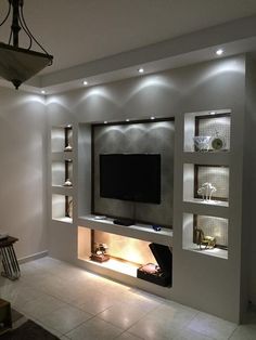 a modern living room with built in shelving and lighting