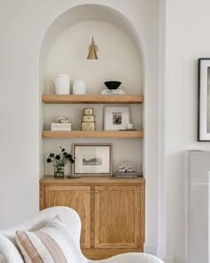 a living room filled with furniture and bookshelves next to a wall mounted fireplace