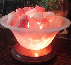 a bowl filled with pink himalayan rocks on top of a wooden table