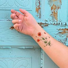 a woman's arm with a small flower tattoo on the left side of her wrist