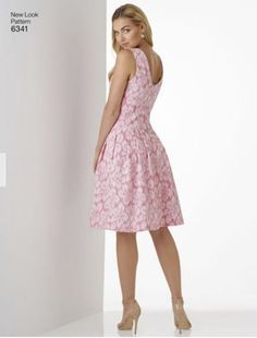 a woman in a pink dress is posing for the camera with her hands on her hips