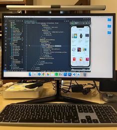 a computer monitor sitting on top of a wooden desk next to a keyboard and mouse