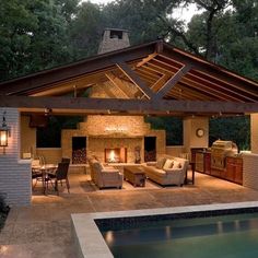 an outdoor living area with a pool and patio furniture, lighting up the night time