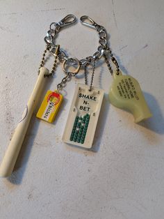 an assortment of items are displayed on a white counter top, including a bottle opener and keychain