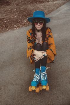 a woman sitting on top of a skateboard with her legs crossed