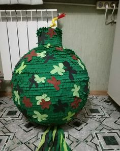 a large green vase sitting on top of a tiled floor