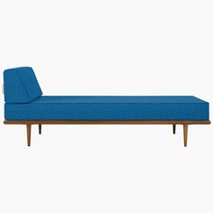 a blue chaise lounger sitting on top of a wooden floor next to a white wall