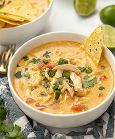 a white bowl filled with chicken tortilla soup and topped with cilantro