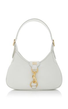 Find MIU MIU Madras Leather Hobo Bag on Editorialist. The Miu Miu 'Madras' hobo bag is crafted in Italy from grained leather. It features a slim silhouette with a large gold clasp and an adjustable shoulder strap. The bag is just roomy enough to store the essentials for the day. White Luxury Bags, Miu Miu Madras Bag, Miu Miu Hobo Bag, Cute Designer Bags, Miu Miu Shoulder Bag, Cute Bags And Purses, Small White Purse, Miumiu Bags, 2024 Bags