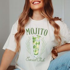 Indulge in the laid-back vibes of summer with our Mojito Social Club Comfort Color Tee, a refreshing addition to any casual wardrobe. Crafted from premium Comfort Color fabric, this tee offers unbeatable softness and comfort, ensuring you stay cool and relaxed all day long. The Mojito Social Club design brings a touch of tropical flair, featuring a cool mojito glass adorned with mint leaves. Whether you're lounging beachside or enjoying a night out with friends, this tee adds a splash of fun to Summer Graphic Print T-shirt For Brunch, Summer Graphic Tee For Brunch, Spring Brunch Graphic Tee T-shirt, Green T-shirt For A Summer Day Out, Green T-shirt For Summer Day Out, Spring Brunch Graphic Tee Shirt, Summer Brunch Cotton T-shirt, Trendy Summer T-shirt For Brunch, Spring Graphic Tee For Brunch