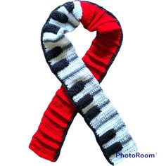 Piano Keyboard scarf is crocheted with lots of embedded texture using red, white, black and grey colors of 100% acrylic yarn. Scarf comes in two sizes. You can choose your size at checkout. 74 X 5 3/4 inches  78 X 6 inches Half of the length is the piano keyboard with a slight 3D effect as the black piano keys are crocheted on top of the white keys, allowing the black keys to appear taller than the white keys - just like on a piano! The other half of the scarf is crocheted with red yarn using a highly textured pattern. The entire scarf is brought together with a thin black band running the entire length as shown in photo. Sure to delight pianists and music lovers of all ages! The perfect gift for a budding musician or that special music teacher. Machine wash. Damp dry. No returns or exchan Piano Scarf Crochet Free Pattern, Piano Key Scarf Crochet, Piano Blanket Pattern, Piano Shawl, Yarn Scarf, Black Piano, Black Keys, Piano Keyboard, Piano Keys