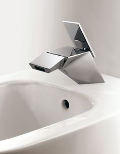 a bathroom sink with a chrome faucet and mirror above it's head