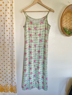 This vintage Pellini dress is a stunning addition to any wardrobe. The floral gingham pattern and green color give it a unique and retro feel, perfect for a day dress occasion. The dress is made in Oman and has a regular size fit, designed for a secretary/geek look. The 90s style and maxi dress design make it a must-have for vintage clothing enthusiasts. The dress is perfect for those who love to stand out in a crowd and make a statement with their fashion sense. Don't miss out on the chance to add this beautiful piece to your collection. Measurements taken while laying flat: Pit to pit- 18" Waist- 18" Length- 43" Green Spring Picnic Dress, Vintage Spring Dresses For Picnic, Green Floral Print Dress For Picnic, Vintage Dresses For Spring Picnic, Green Floral Print Dresses For Picnic, Green Floral Print Dresses For Picnics, Spring Retro Gingham Dress, Fitted Gingham Dress With Floral Print, Spring Cottagecore Green Dress