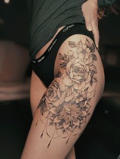 a woman's thigh with tattoos and flowers on her thighs, showing the back