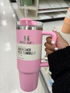 a person holding a pink tumbler in their hand