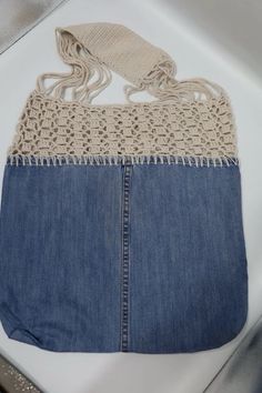 an old pair of jeans with crochet on the bottom and sides are sitting on a table